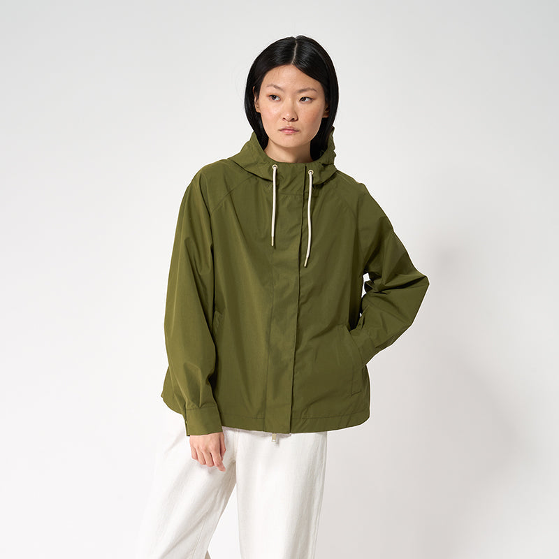 Person wearing a green raincoat on a white background