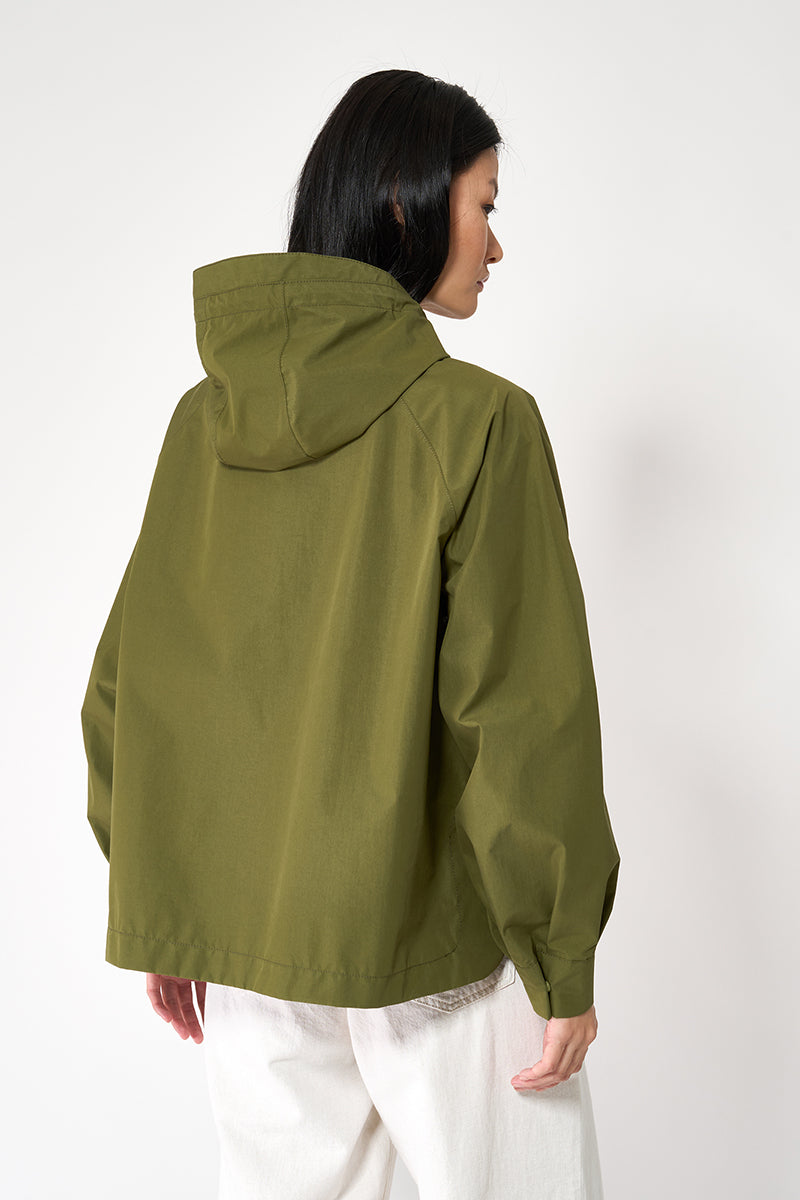 Person wearing a green raincoat on a white background