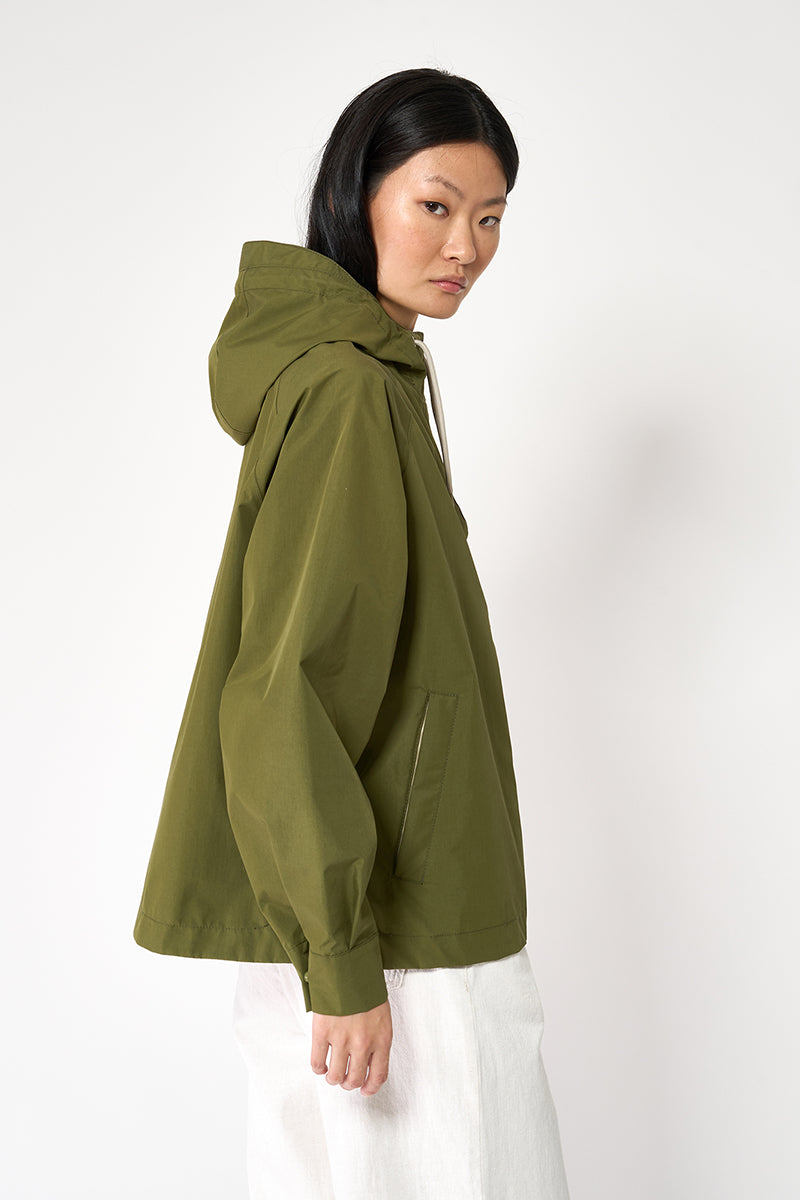 Person wearing a green hooded jacket on a white background