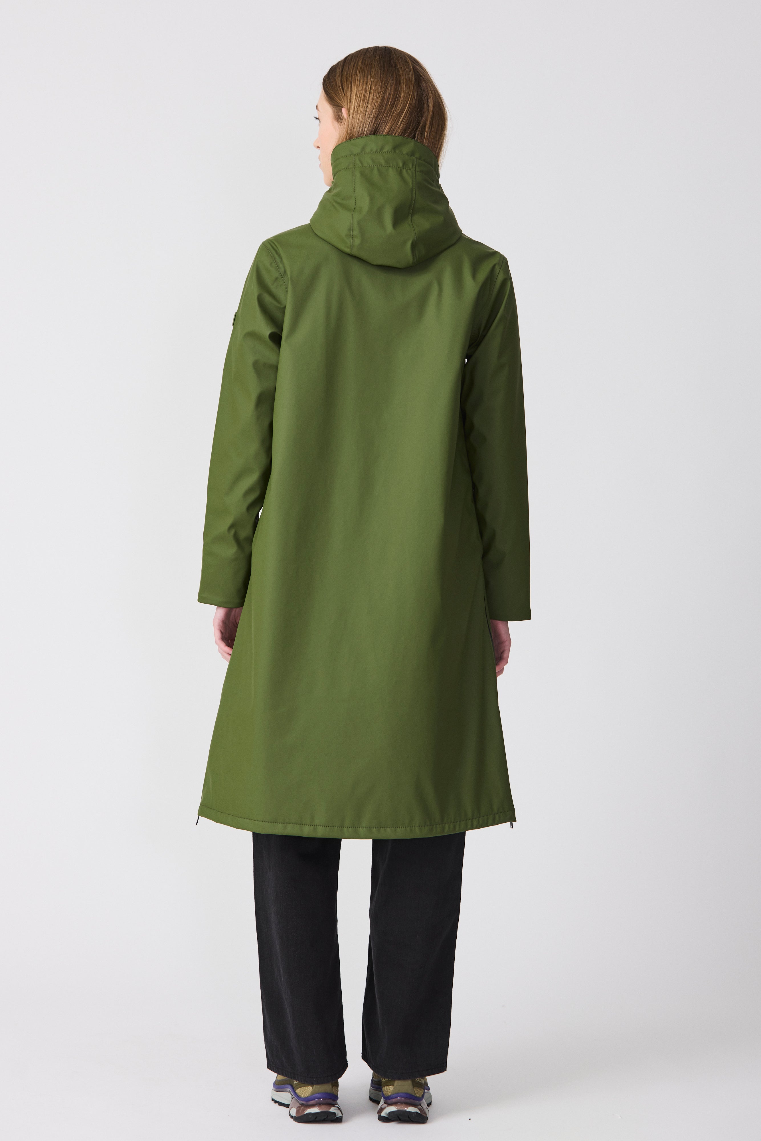 Person wearing a green coat on a white background
