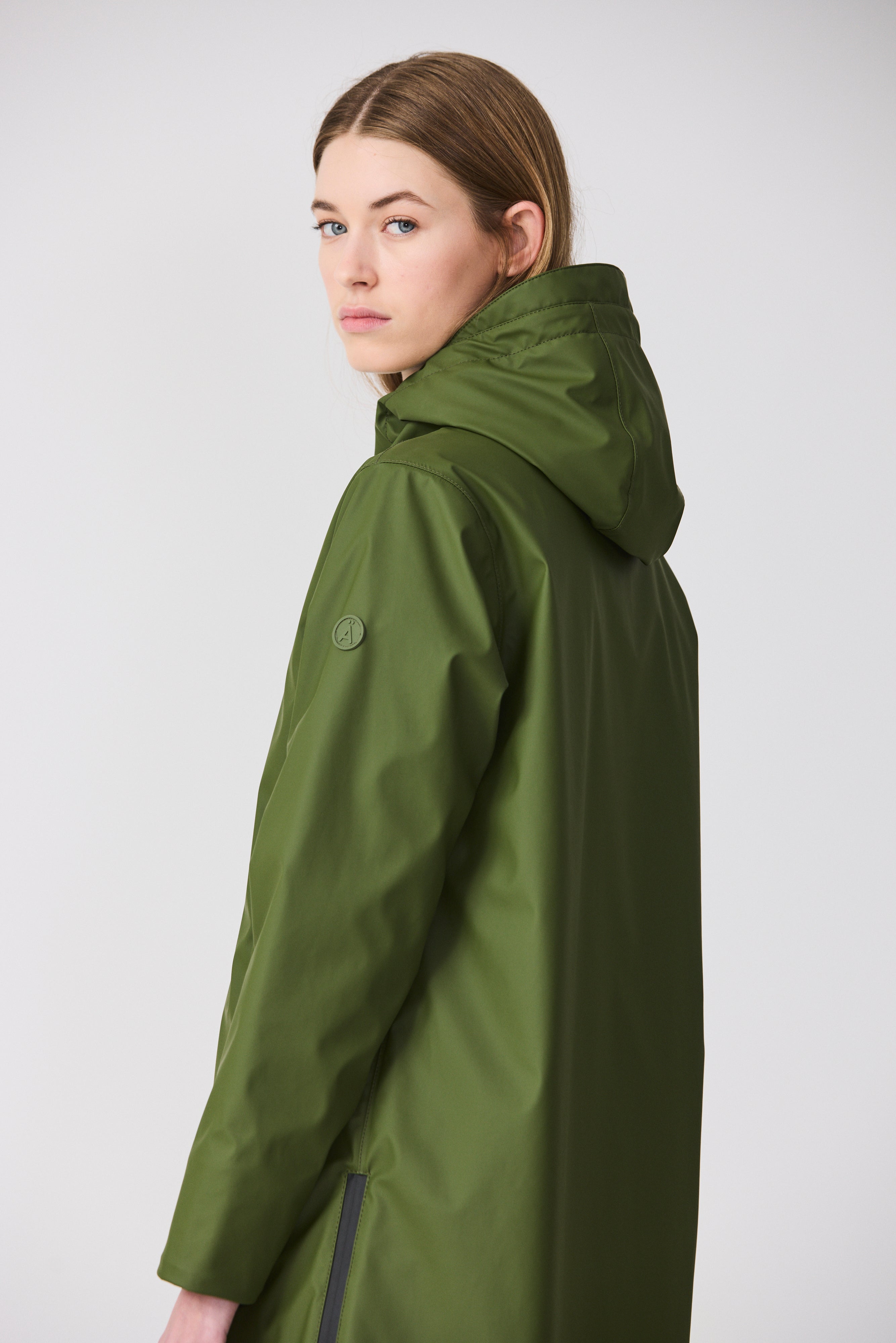 Person wearing a green raincoat on a white background