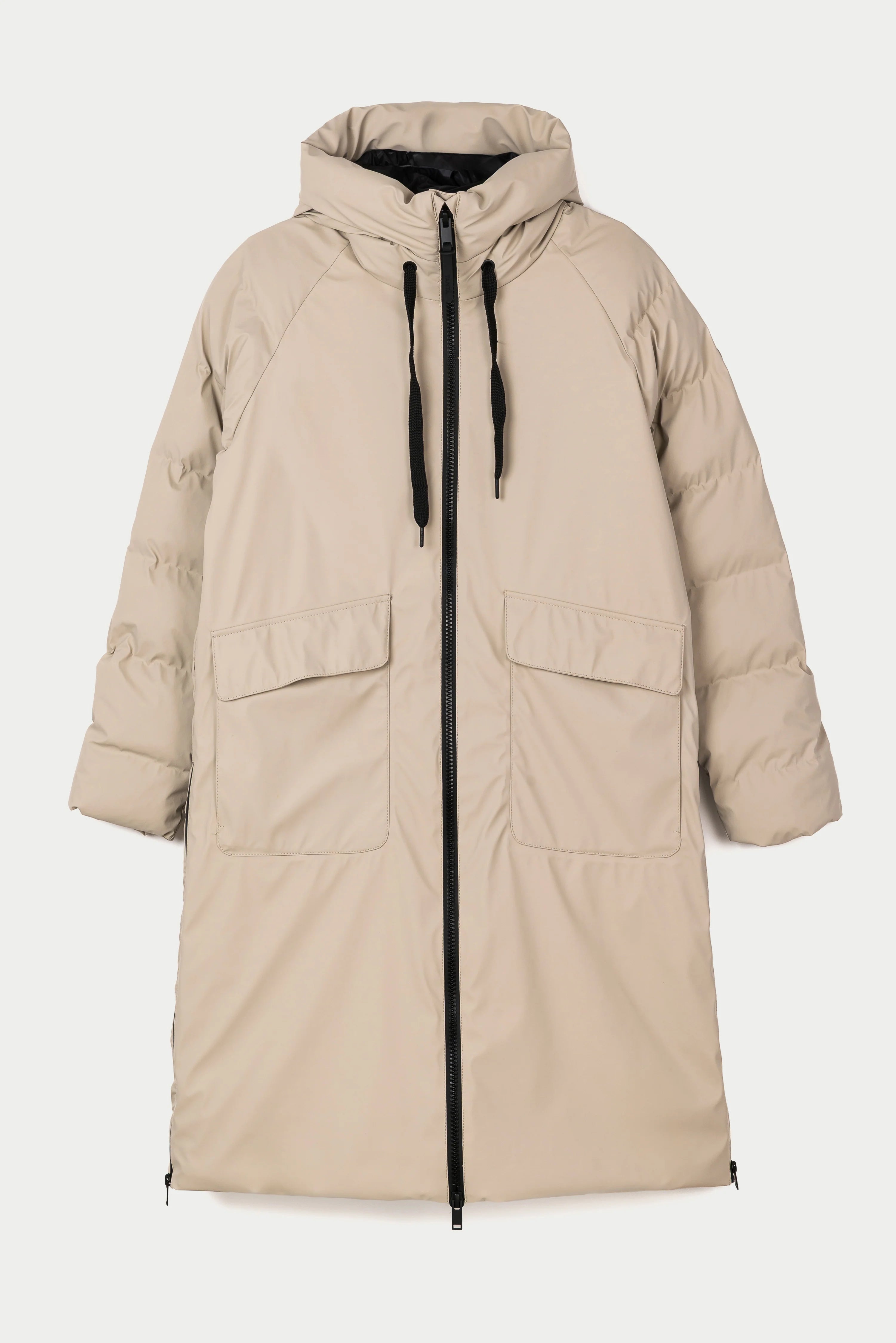 A long hooded puffer coat in a light beige or sand color, featuring a black front zipper, black drawstrings, and large front flap pockets, shown against a plain light gray background.