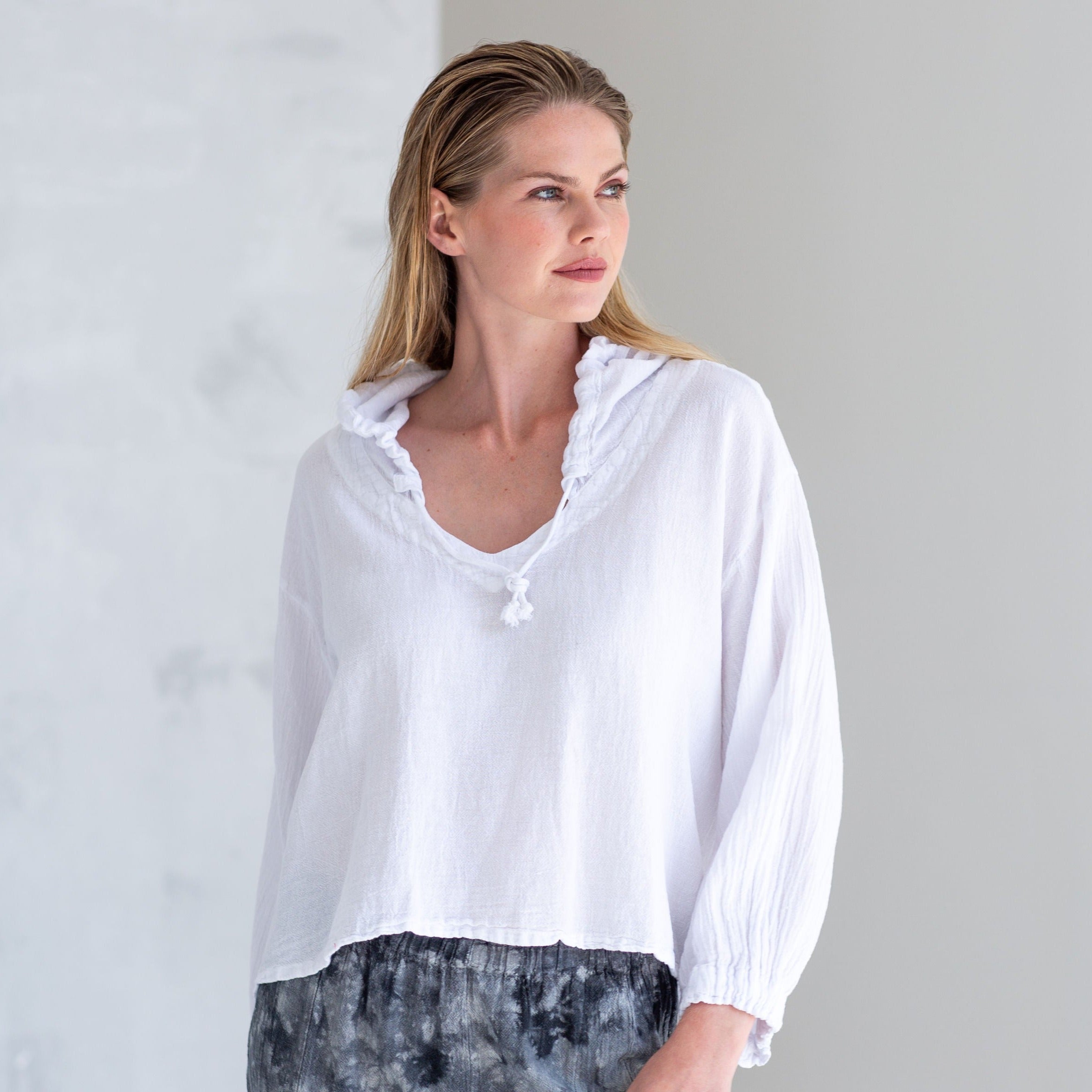 White hooded linen top with drawstring neckline and three-quarter sleeves.  Cropped, relaxed fit.