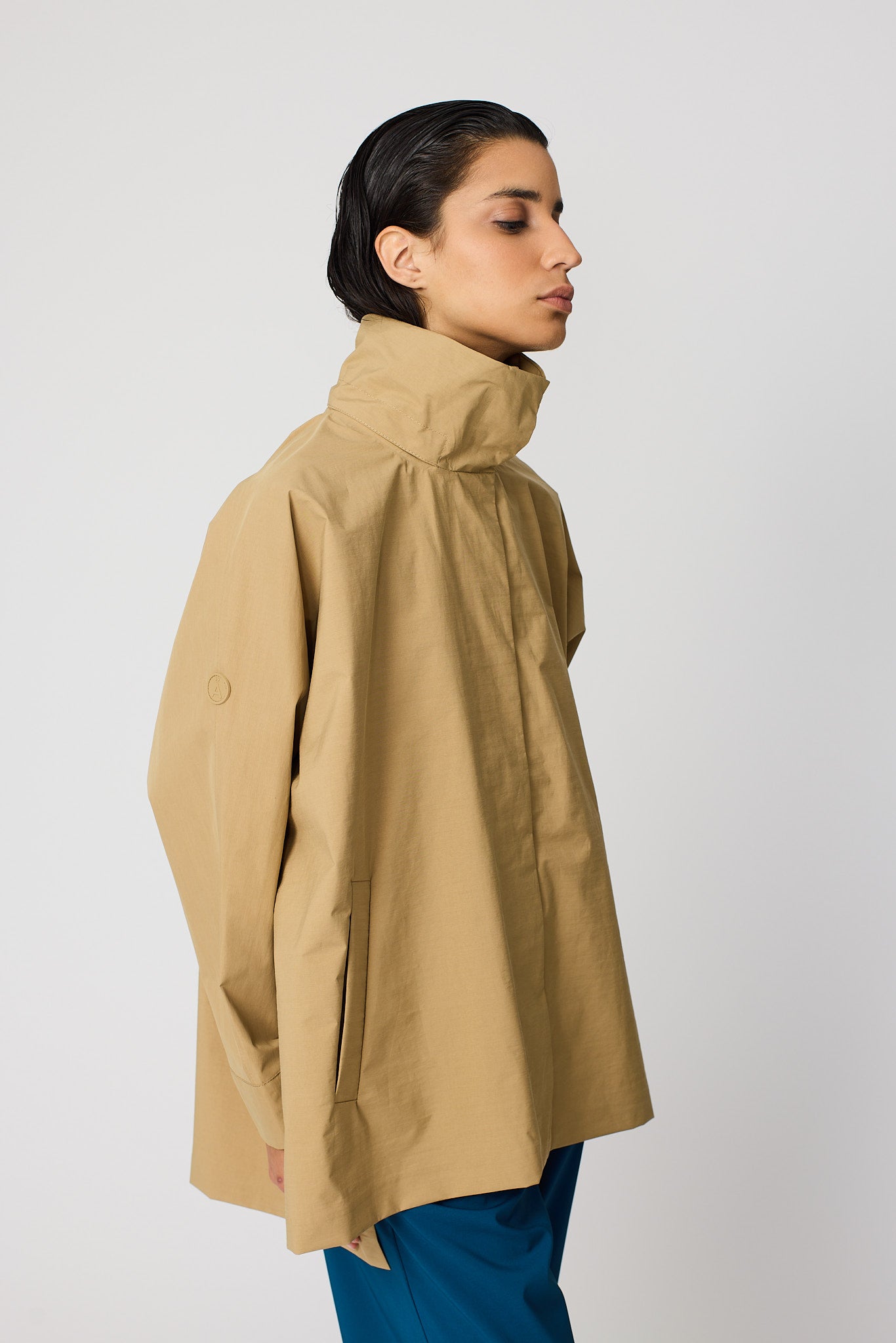 Woman wearing a beige coat against a white background