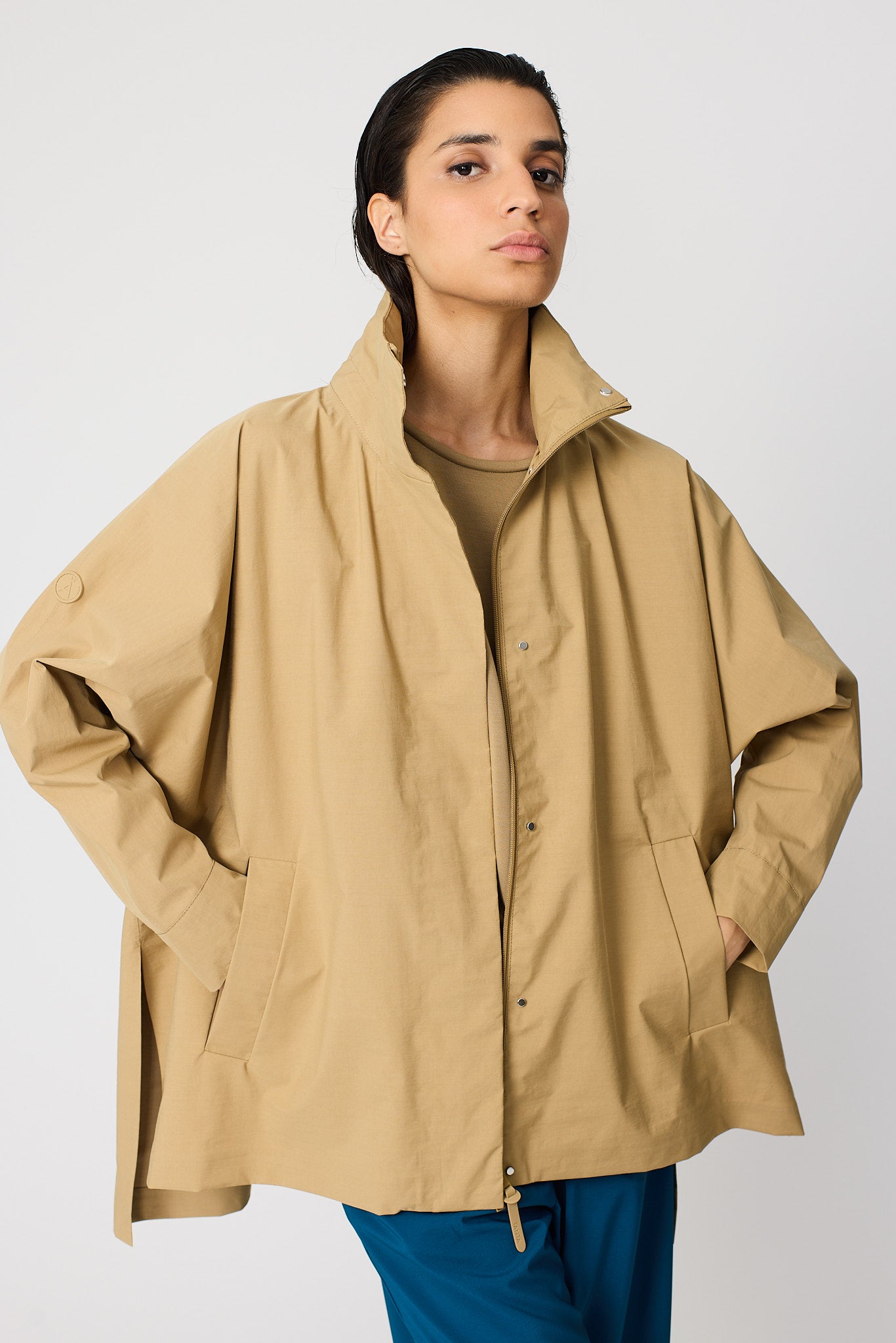 Person wearing a beige jacket on a white background