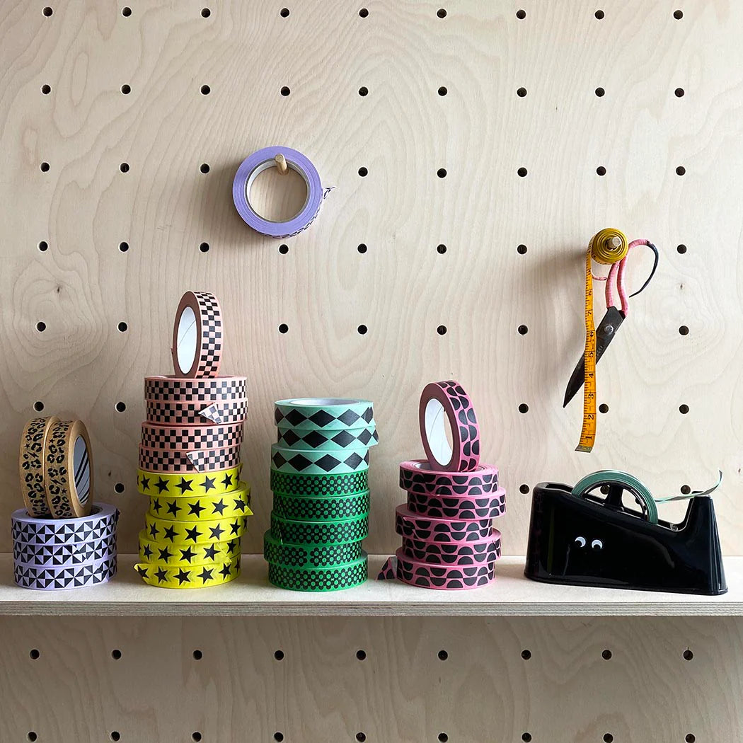Stacks of decorative washi tapes with various patterns: leopard print, checkers, stars, diamonds, and semicircles.