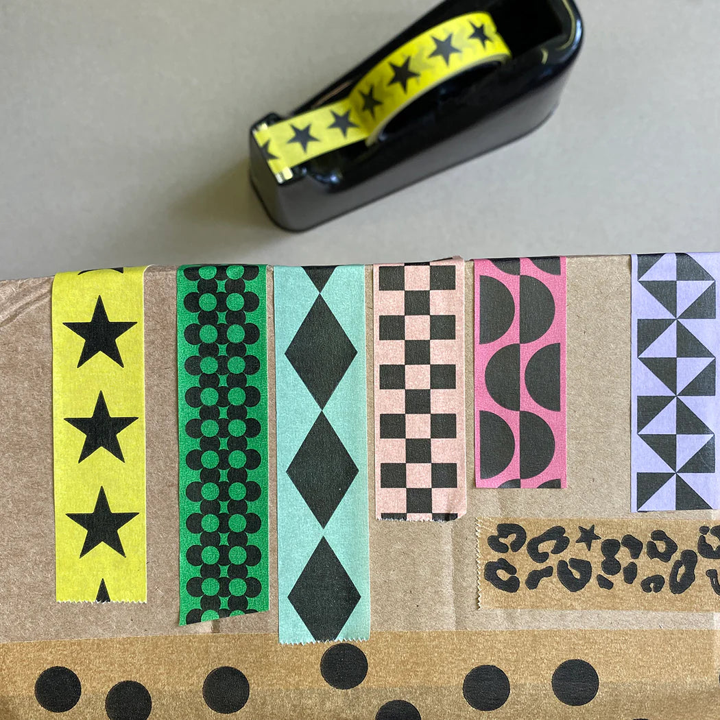 Assortment of patterned washi tapes on cardboard; designs include stars, polka dots, diamonds, checkers, semicircles, and