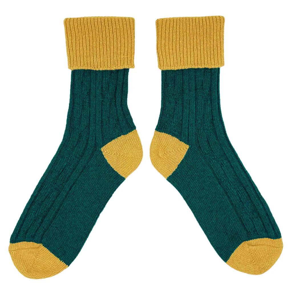 Pair of green socks with yellow accents on a white background