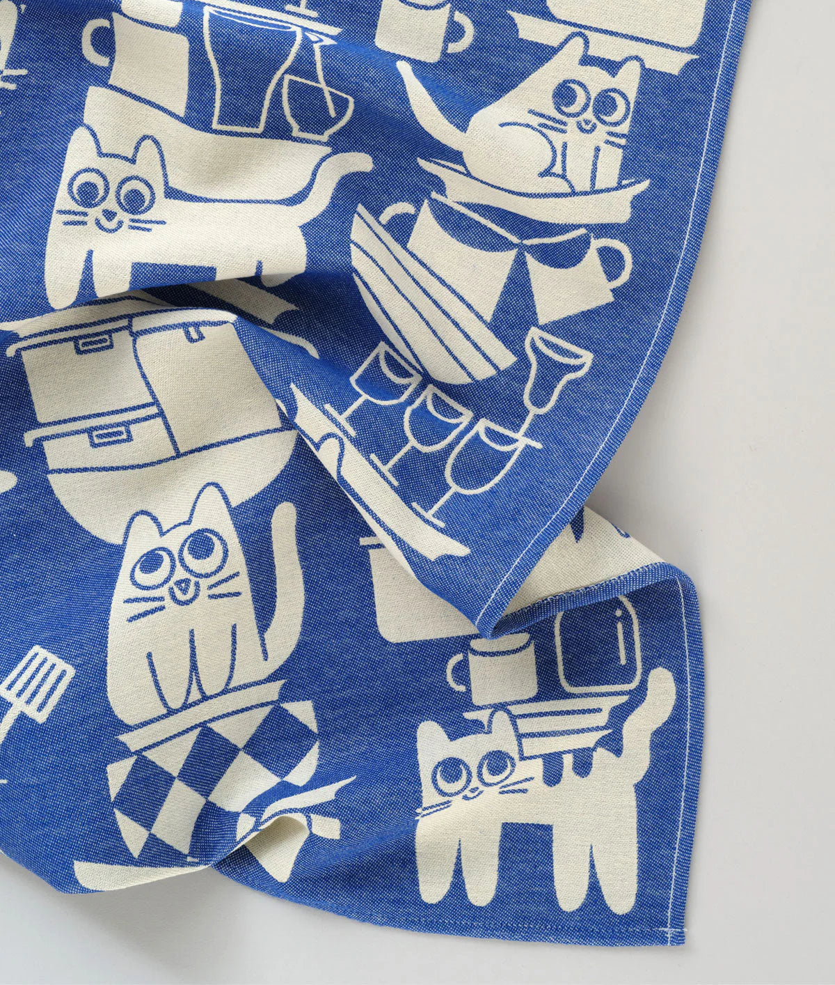 Blue fabric with white cat illustrations on a white background