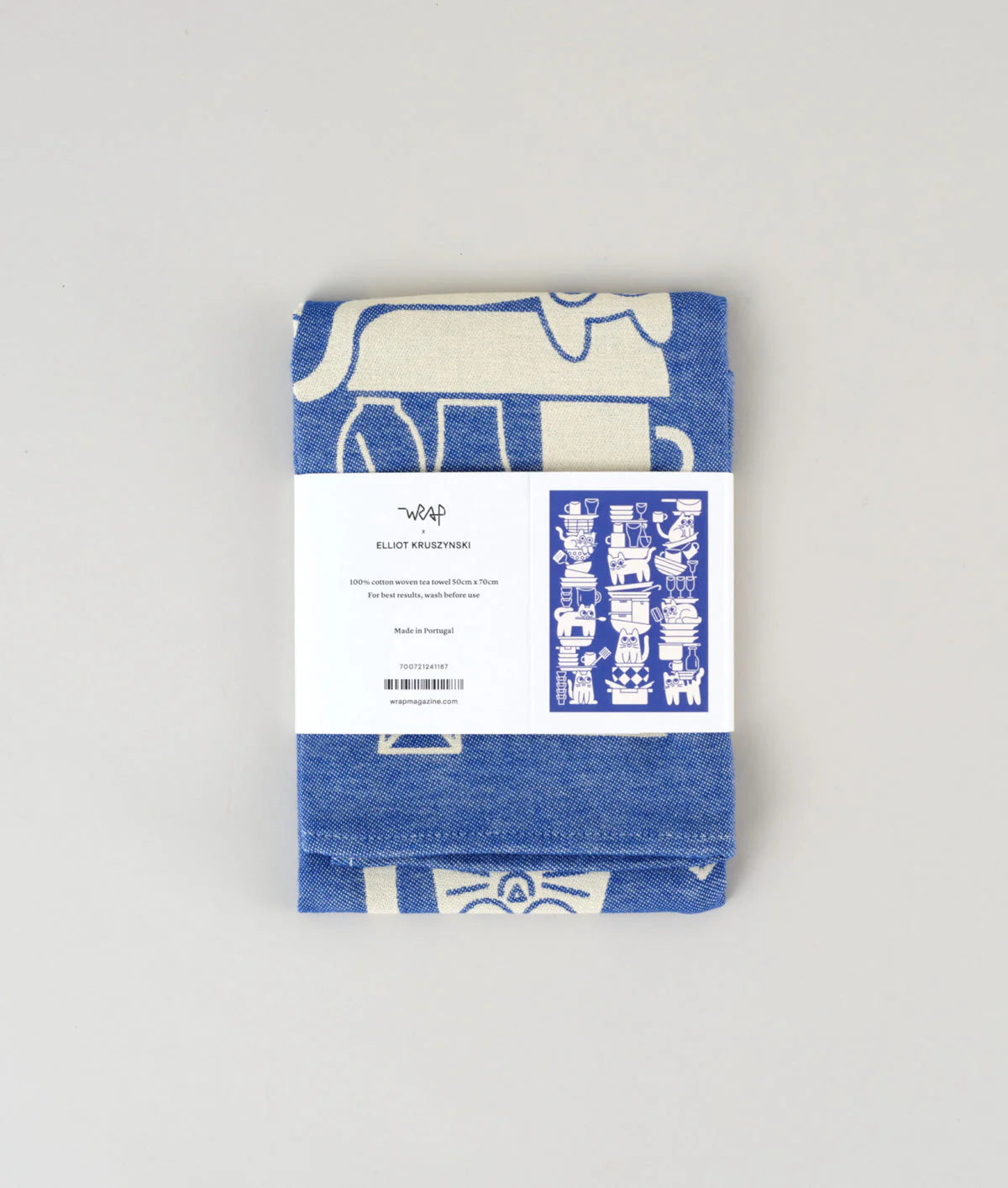 Folded blue and white patterned fabric with a label on a light gray background
