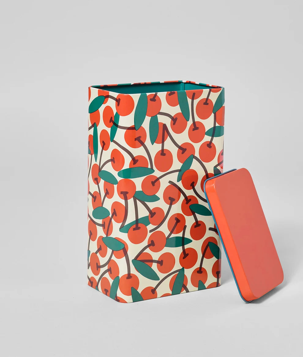 Tin box with cherry pattern and matching red cover on a light gray background