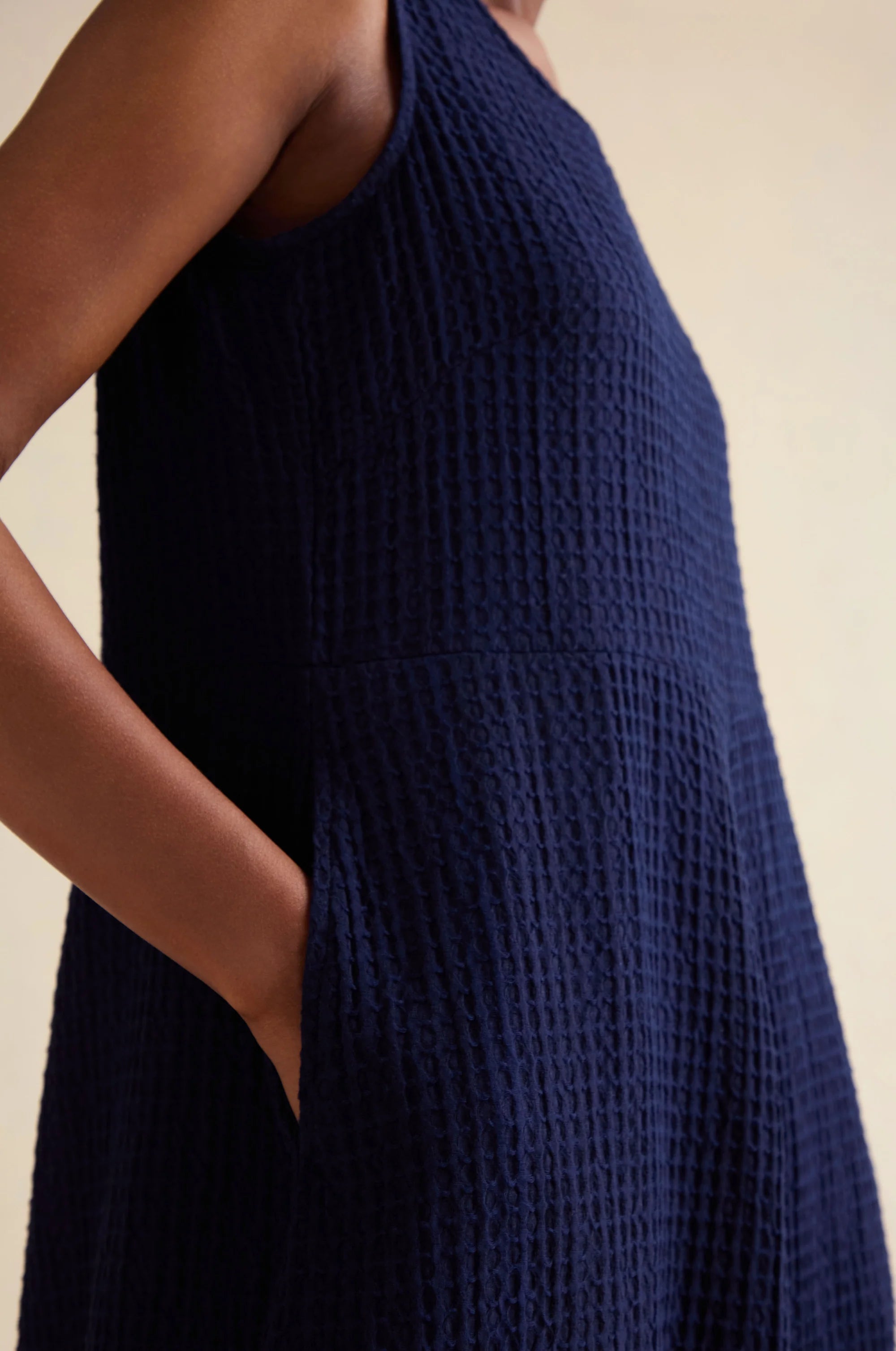 Navy blue textured dress worn by a person on a neutral background