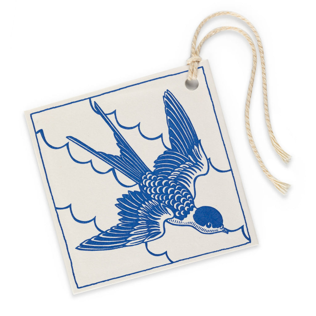 Square gift tag with a blue swallow illustration and cream background.
