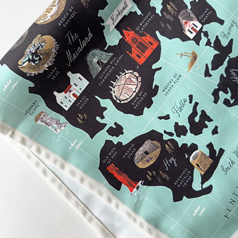 Teal and black illustrated tea towel depicting a stylized map of Orkney, Scotland, highlighting various landmarks.