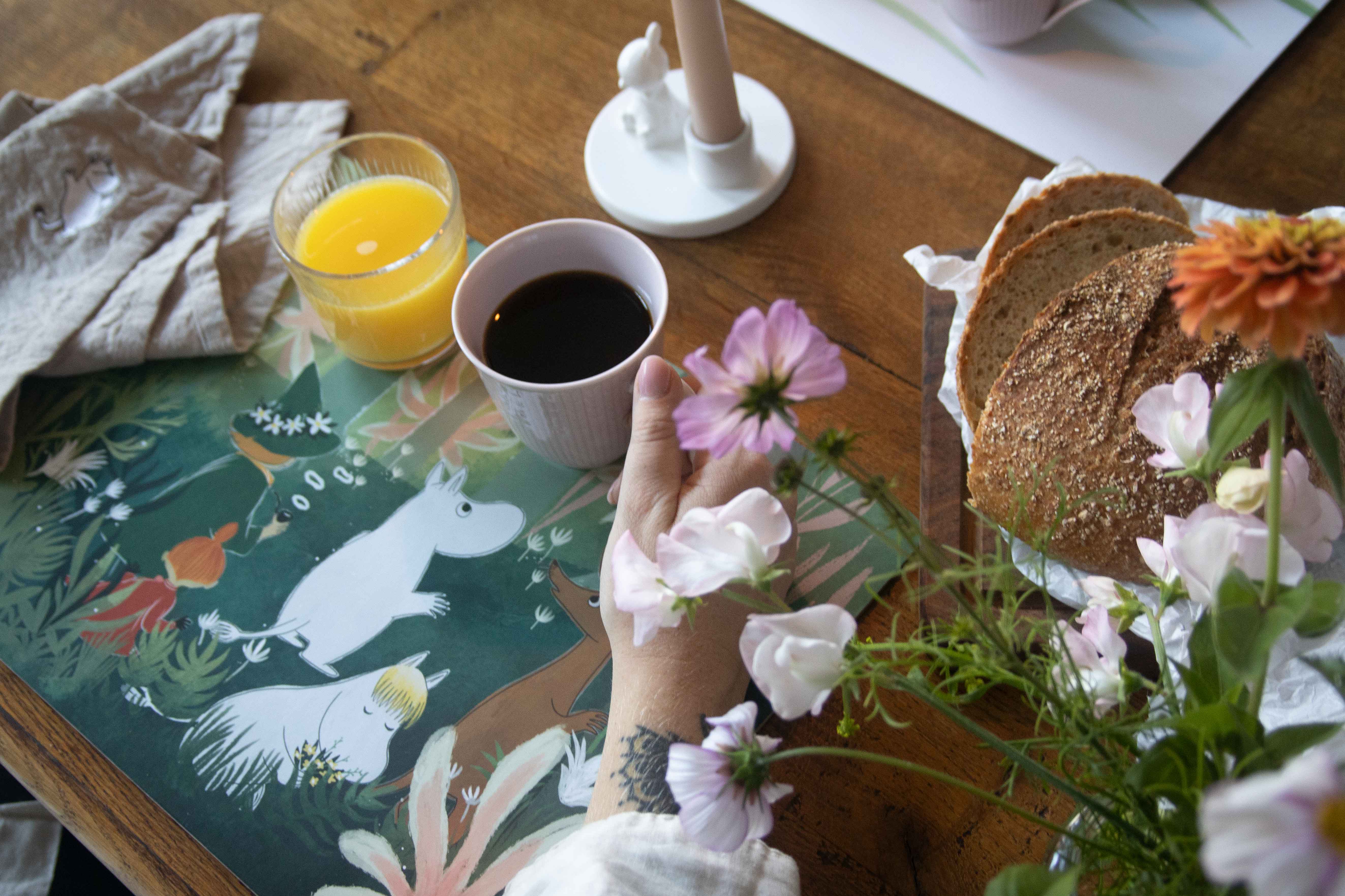 Moomin-themed placemat featuring illustrations of Moomintroll and other characters from the Moomin stories, accompanied by a