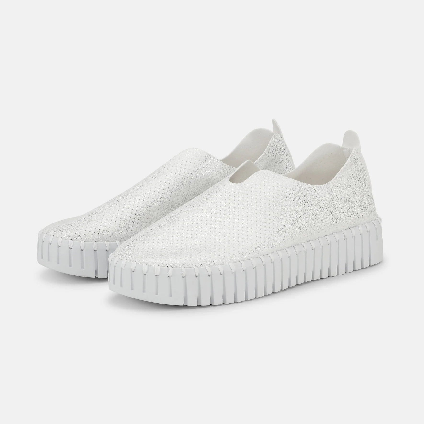 Pair of white slip-on sneakers with textured, perforated uppers and a ridged sole.