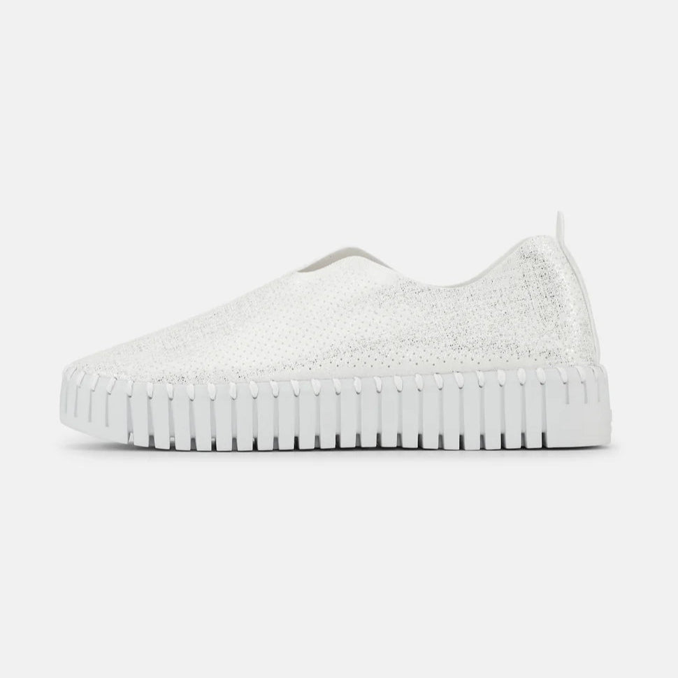 White slip-on sneaker with textured, subtly sparkly upper and a ridged sole.