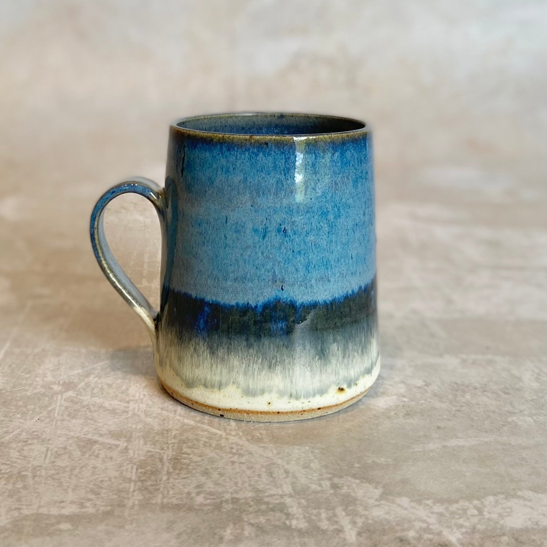 Hand-thrown stoneware mug with a blue, grey, and white gradient glaze.