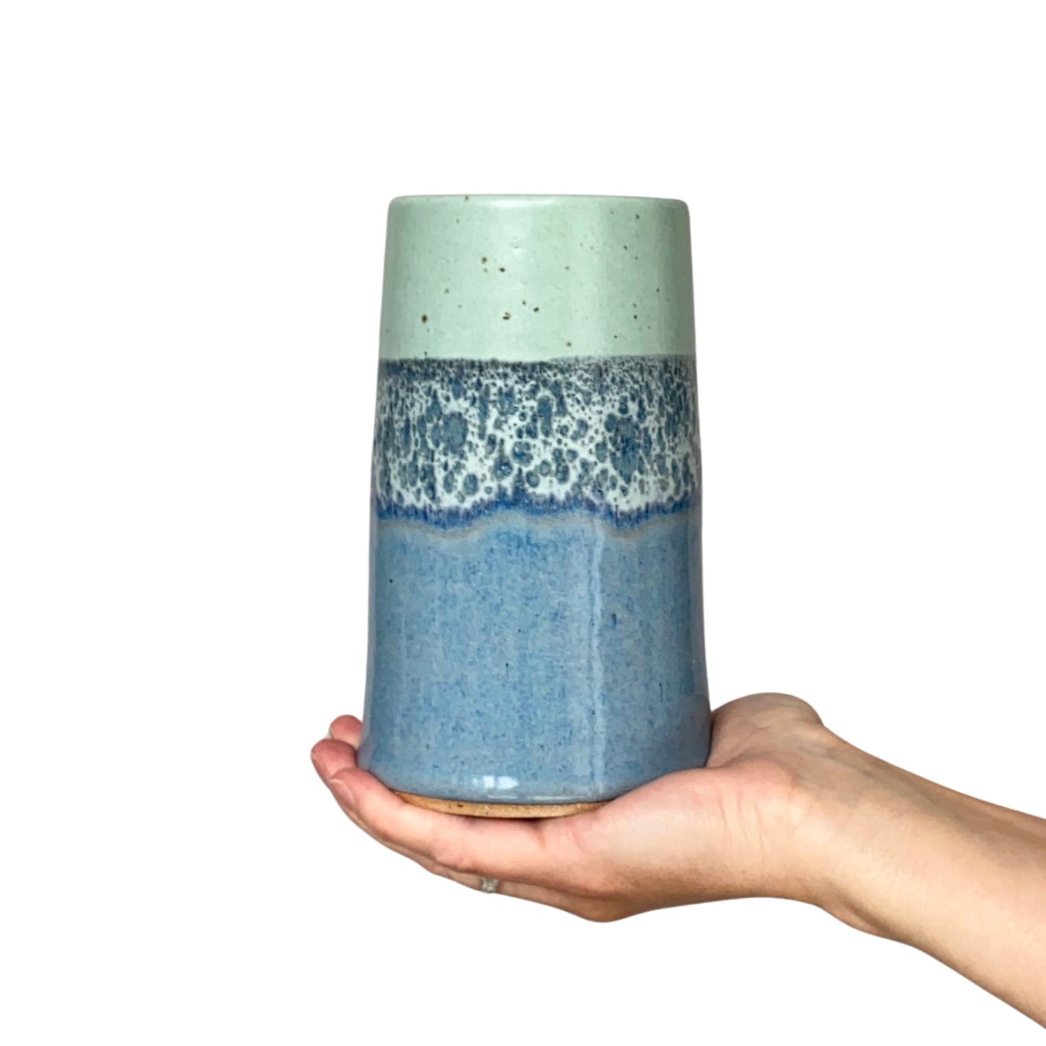 Hand-held ceramic vase with a light green top, a speckled midsection, and a solid blue base.
