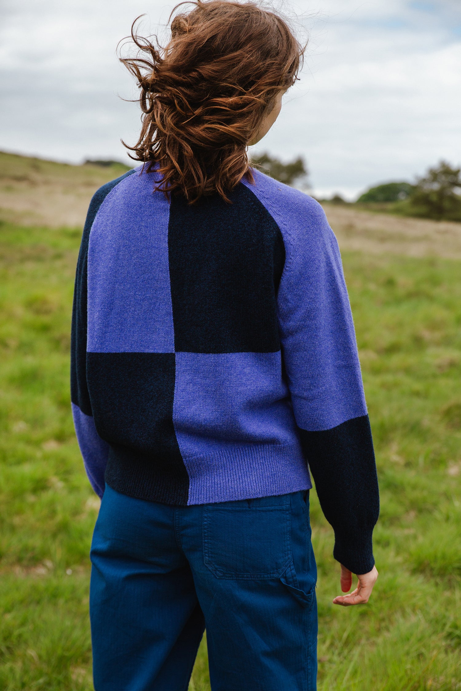 Purple and navy blue checkered knit sweater, long sleeves, relaxed fit.