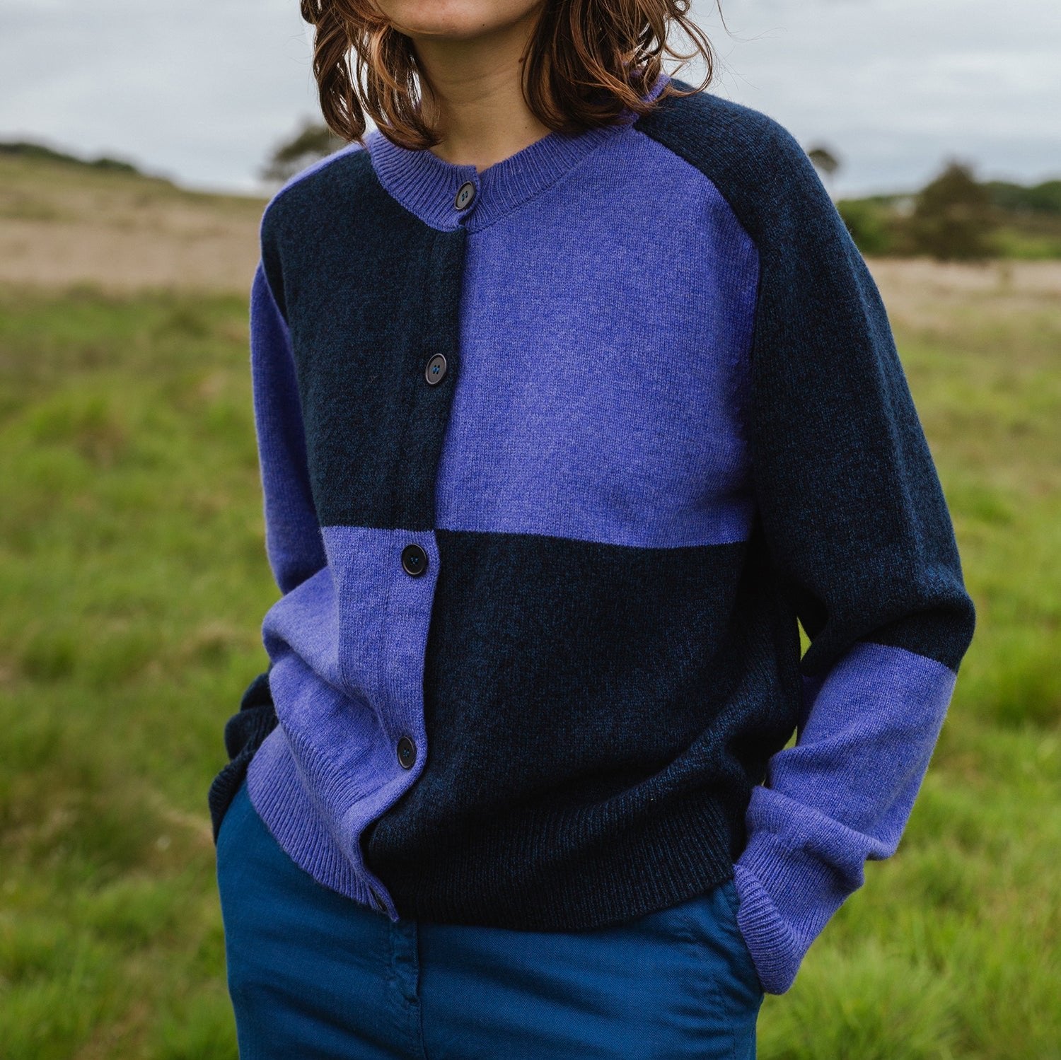 Color-blocked button-front cardigan in shades of purple and dark blue.  Knitted wool construction.