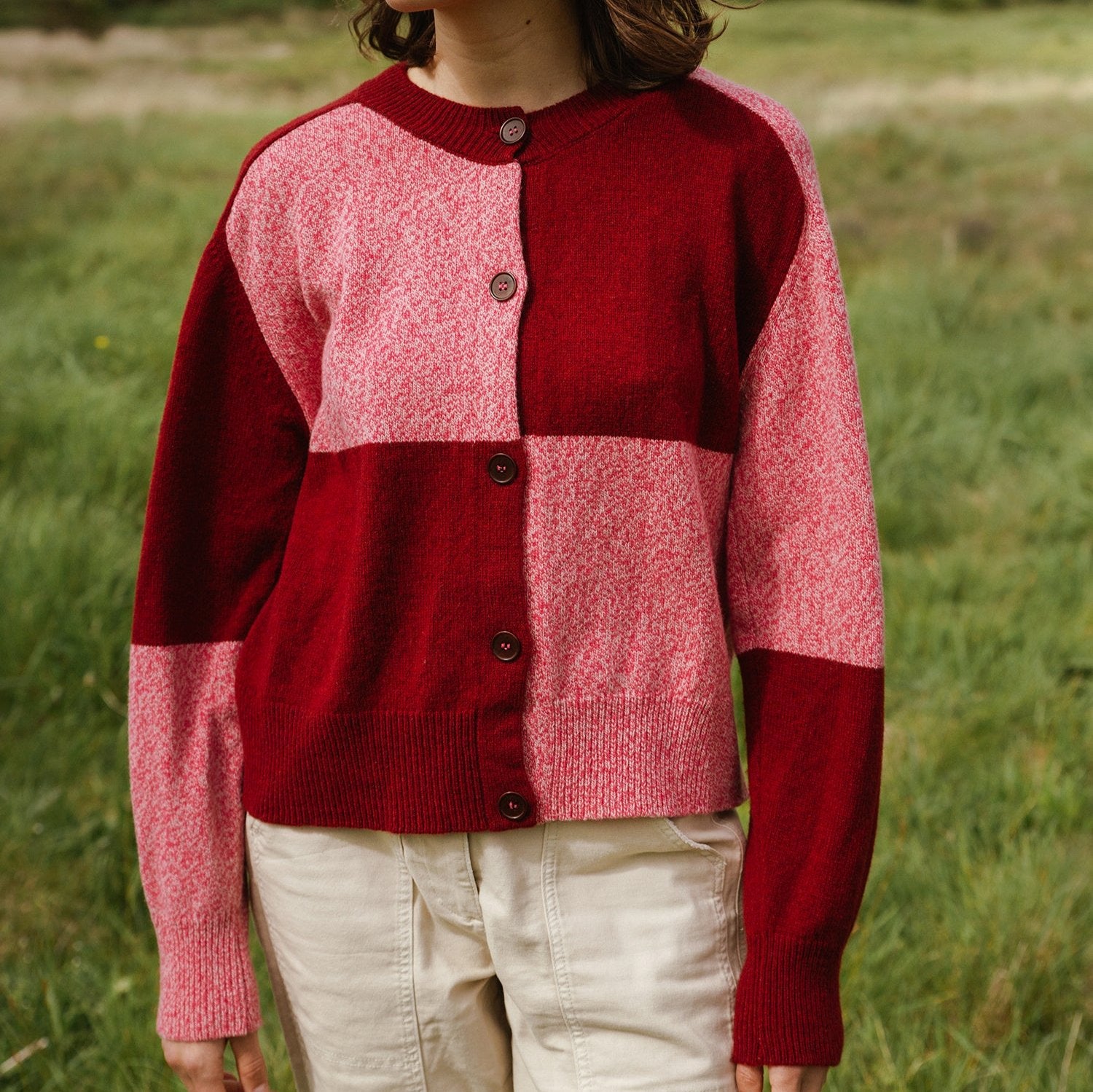 Red and pink color-blocked knit cardigan with button front.