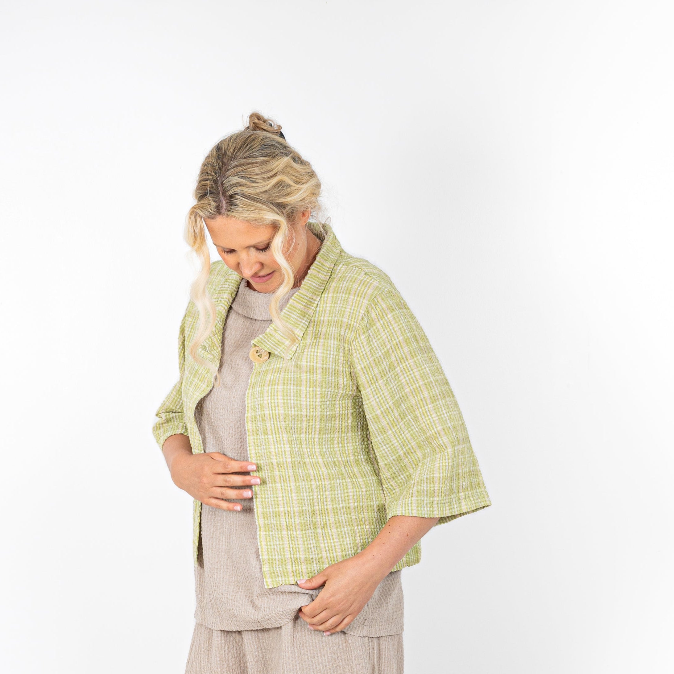 Woman wearing a green checkered jacket on a white background