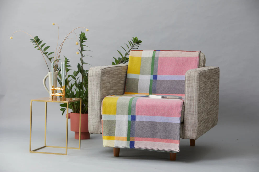 Chair with a colorful checkered blanket on a gray background