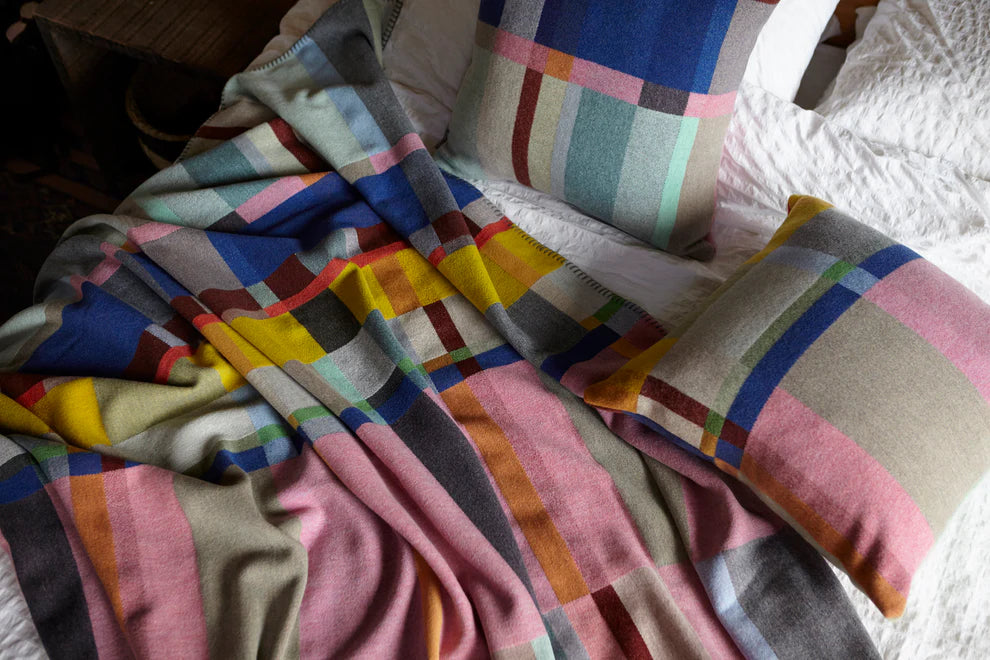 Colorful plaid blanket and pillows on a bed