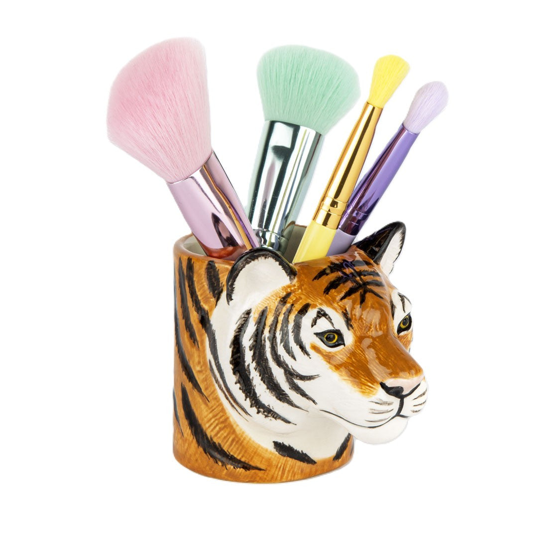 Set of makeup brushes in a tiger-shaped holder on a white background