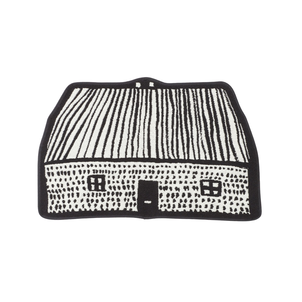 Black and white patterned mat resembling a house, designed by Donna Wilson.