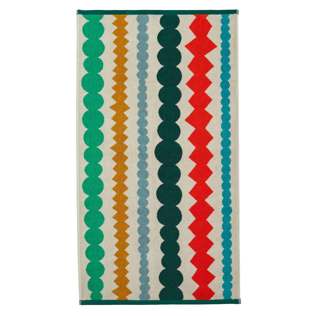 Donna Wilson patterned rug featuring green, red, teal, gold, and grey stripes on a cream background.