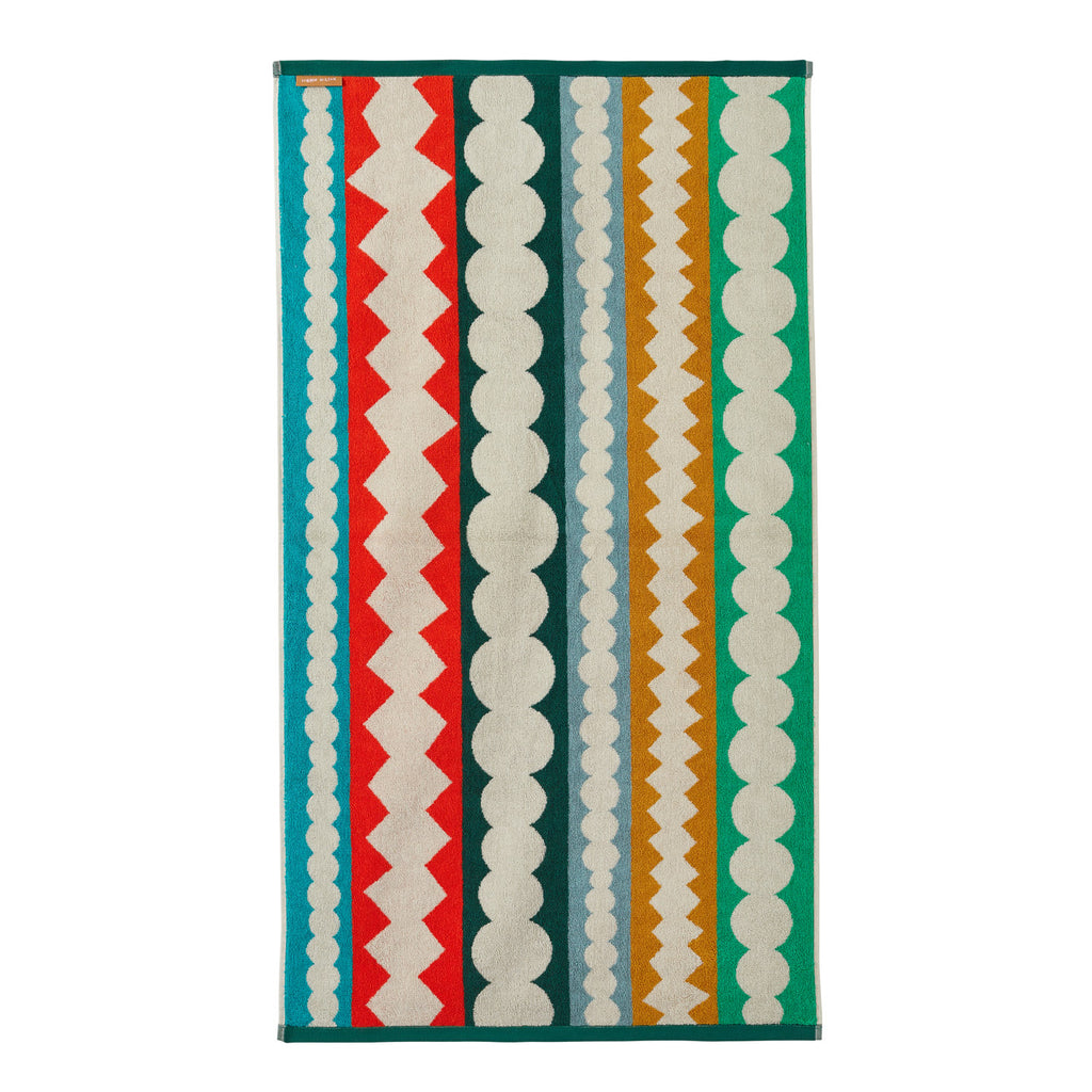 Multi-colored striped rug by Donna Wilson featuring red, green, beige, orange, and blue patterns.