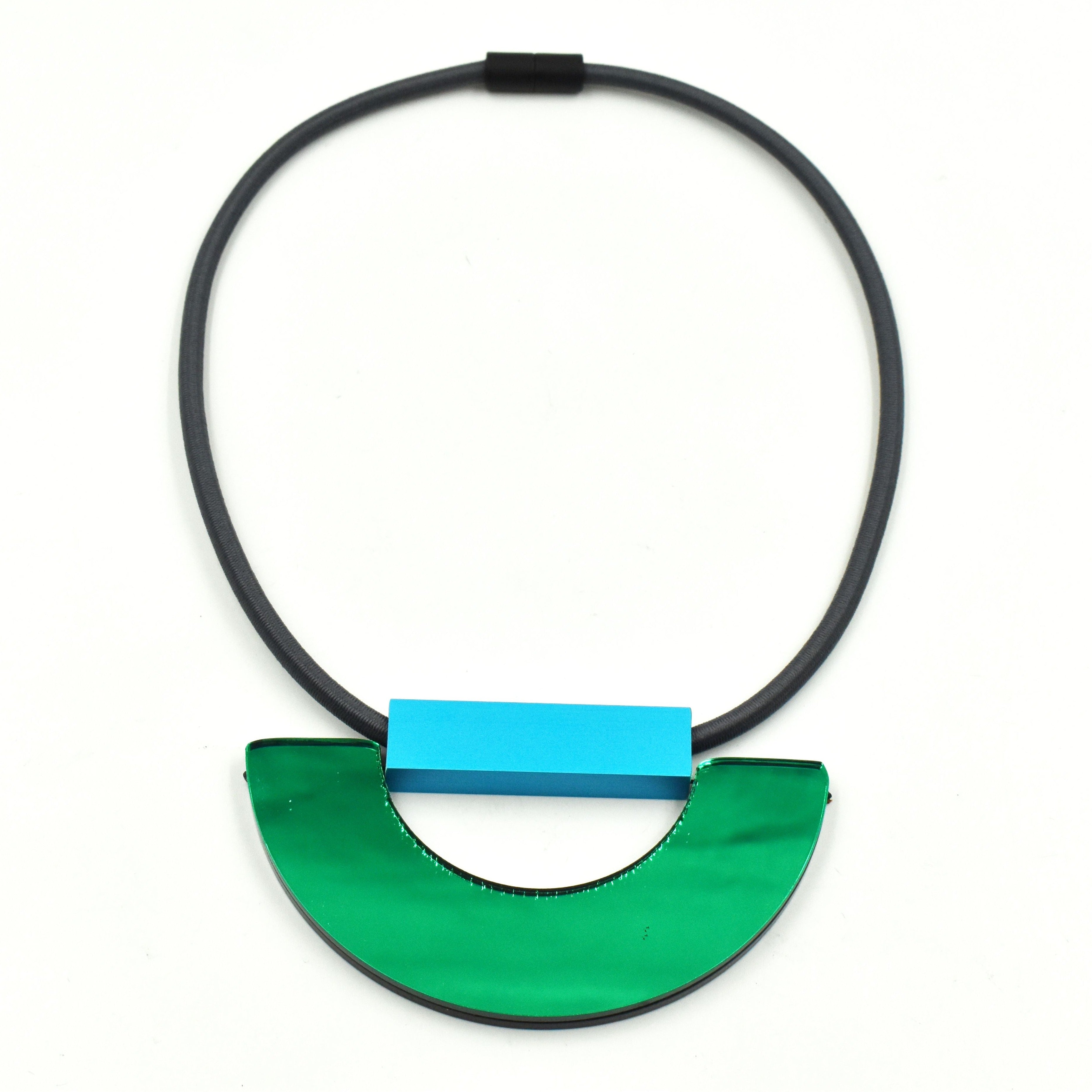 Modern necklace with a dark gray cord and a pendant featuring a bright teal rectangular element and a half-circle of glossy