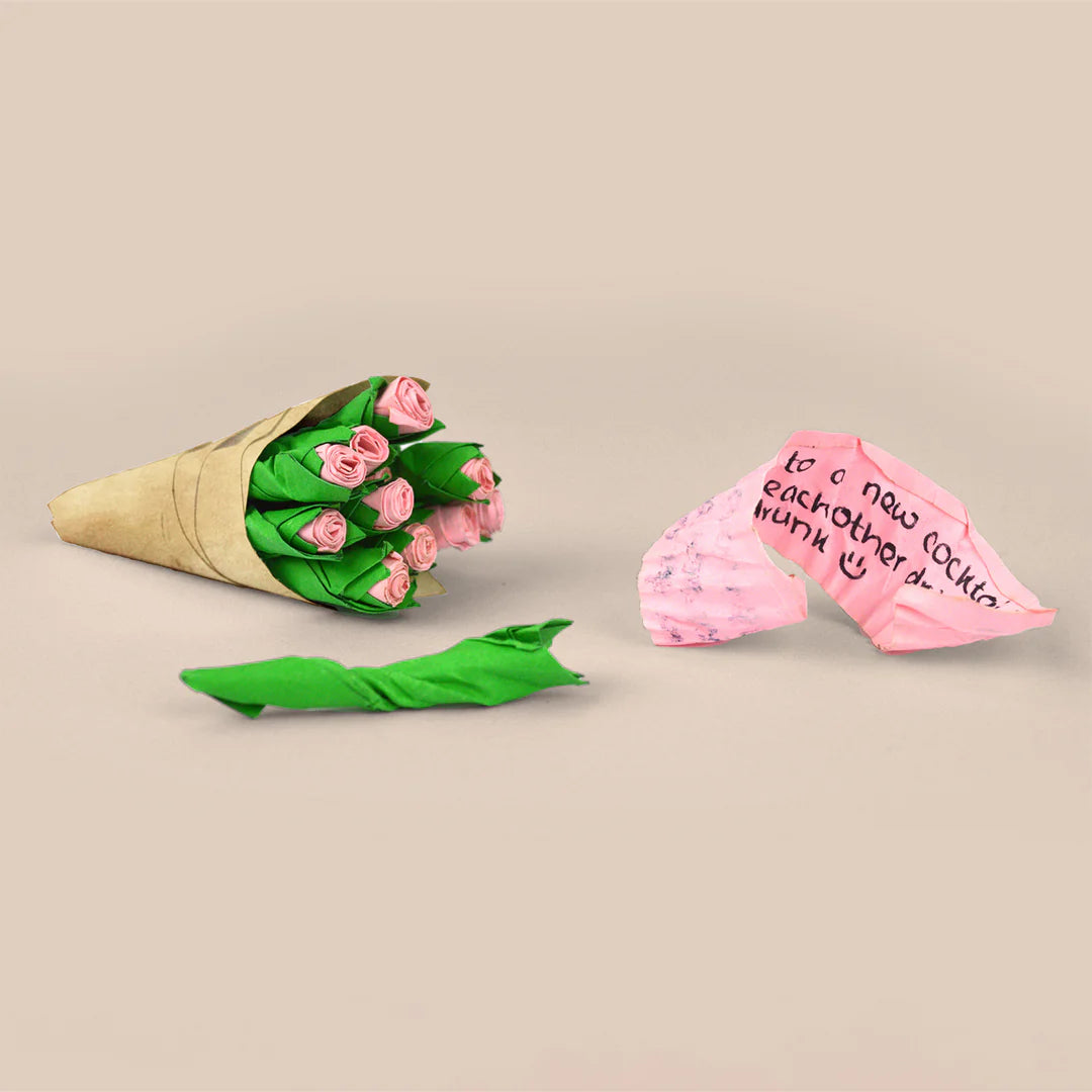 Bouquet of pink roses in a cone with a pink card on a beige background
