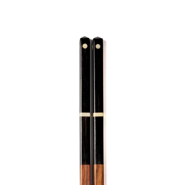 Pair of black and brown chopsticks with ivory accents.