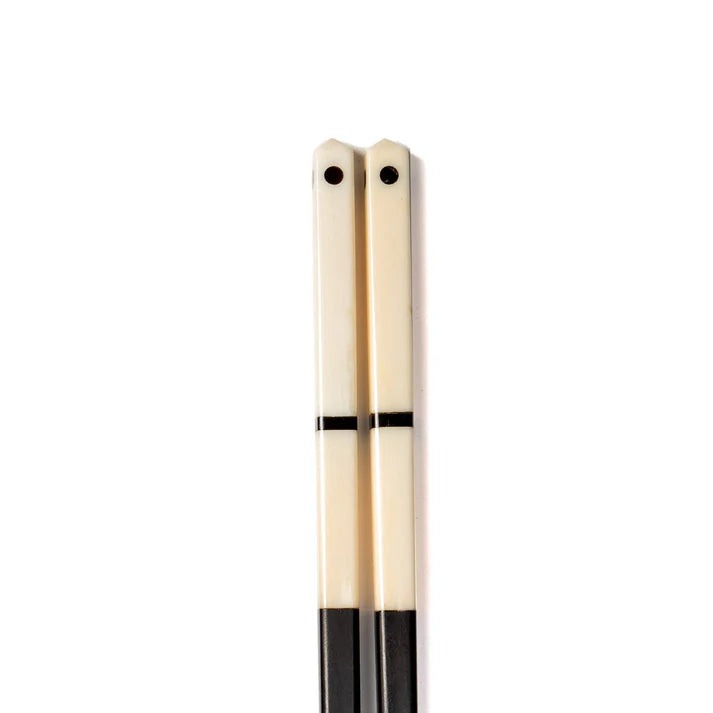 Pair of ivory chopsticks with black accents near the tips.