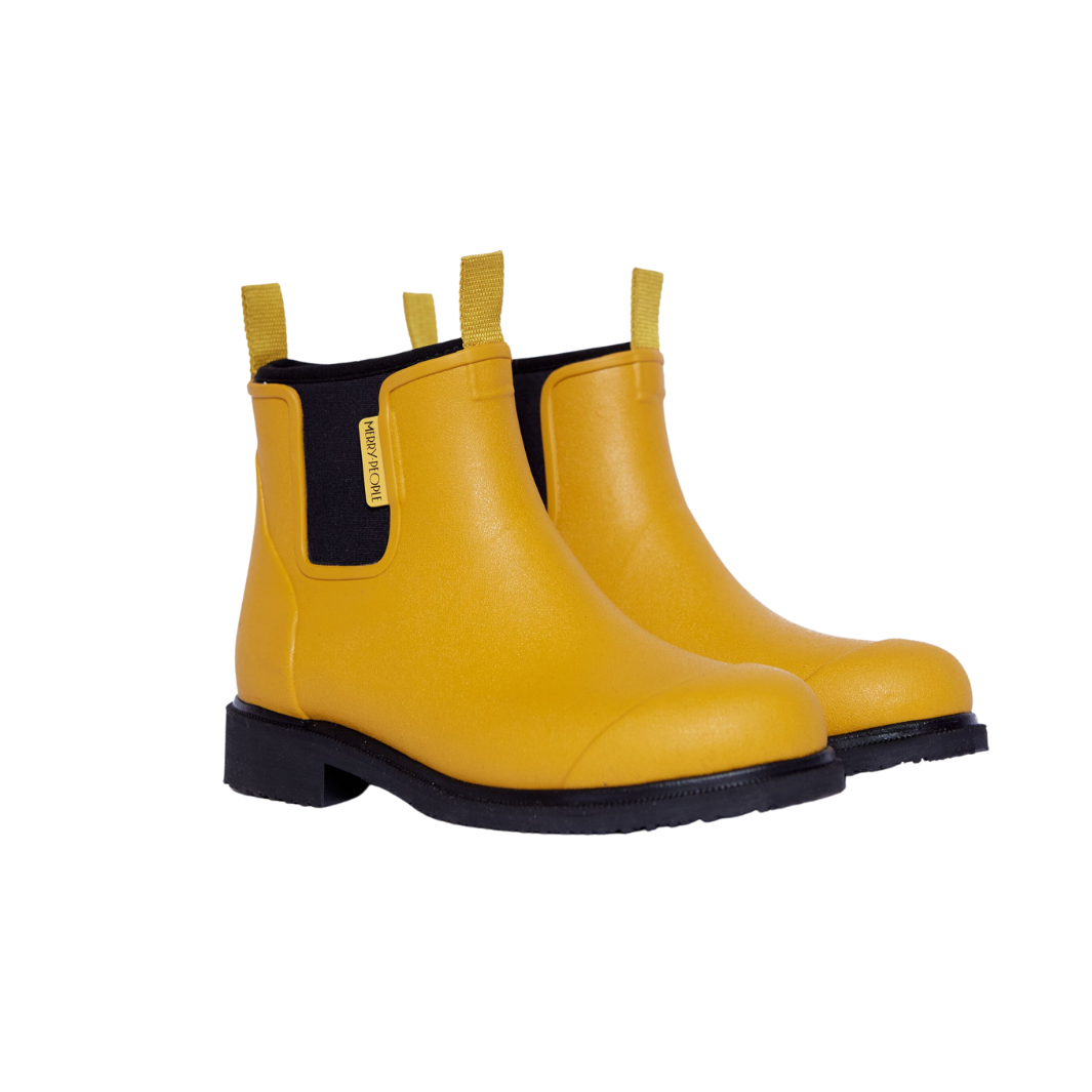 Pair of mustard yellow rubber ankle boots with black soles and pull tabs.