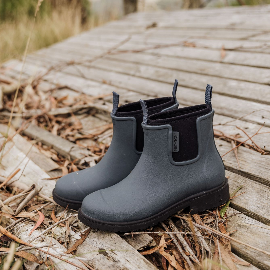 Pair of dark gray rubber ankle boots with black elastic side panels and lug soles.