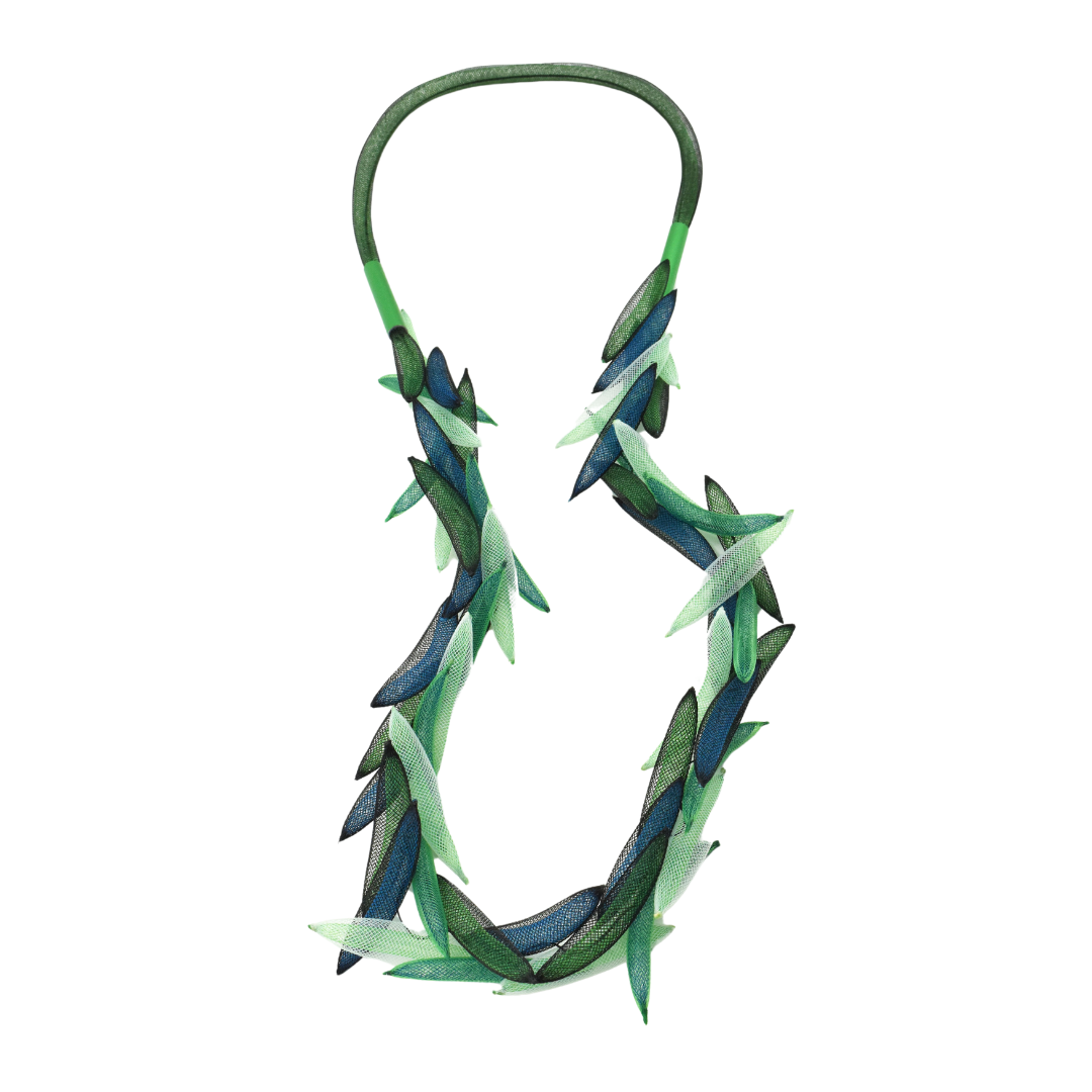 A necklace with a geometric pattern featuring mesh and anodised aluminium with a silk cord.