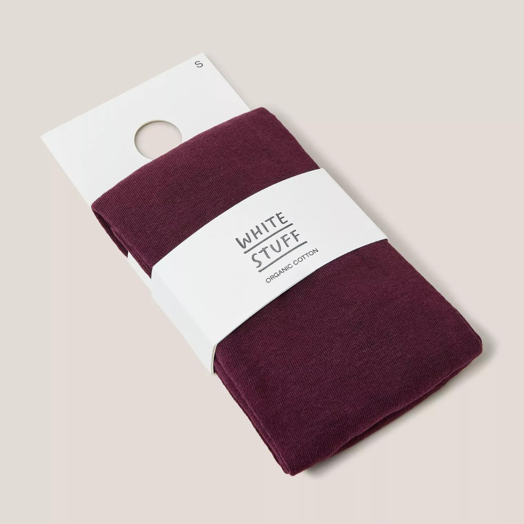 Burgundy organic cotton tights folded on a white label, size small.