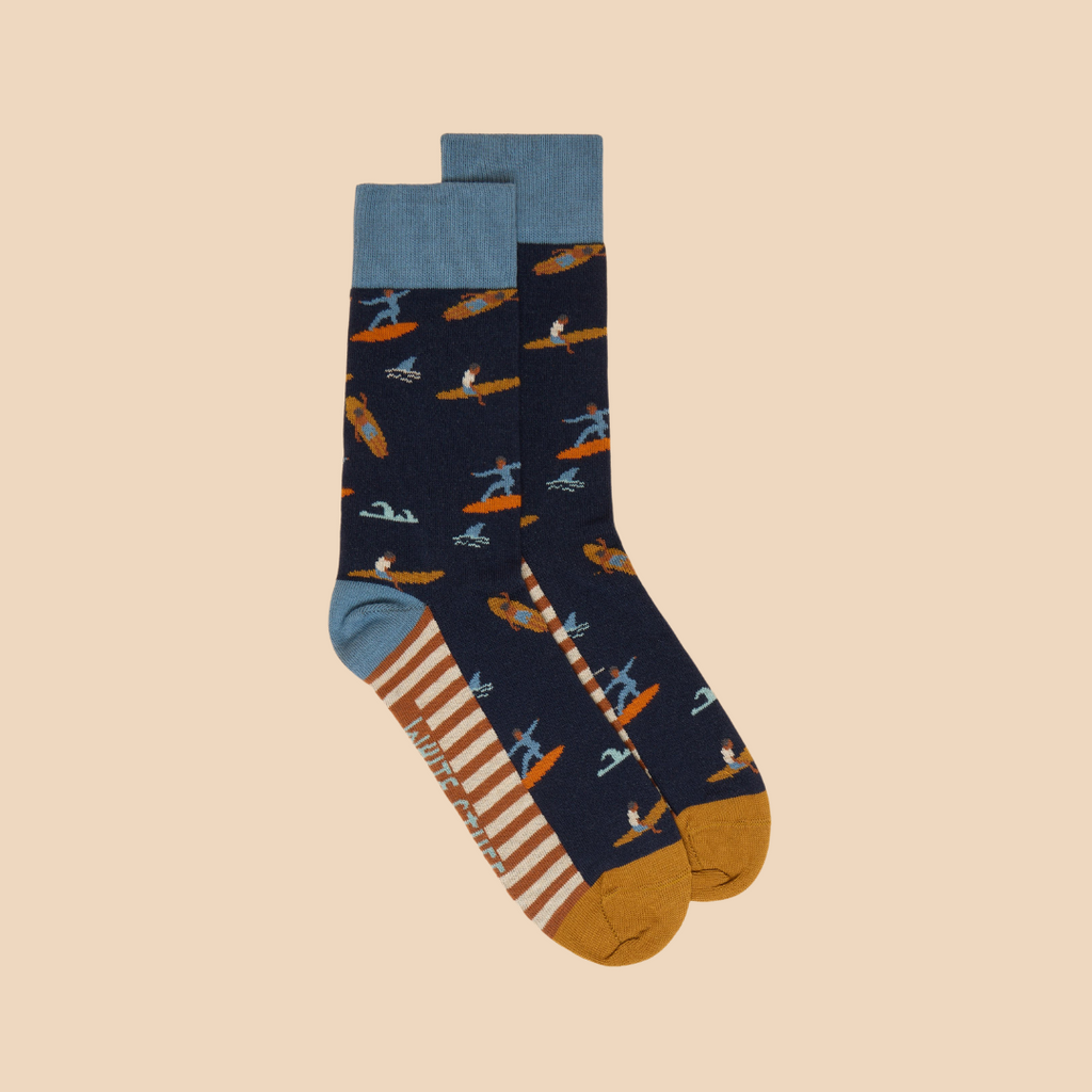 Pair of navy blue socks with a surfer pattern, orange and light blue accents, and striped cuffs.