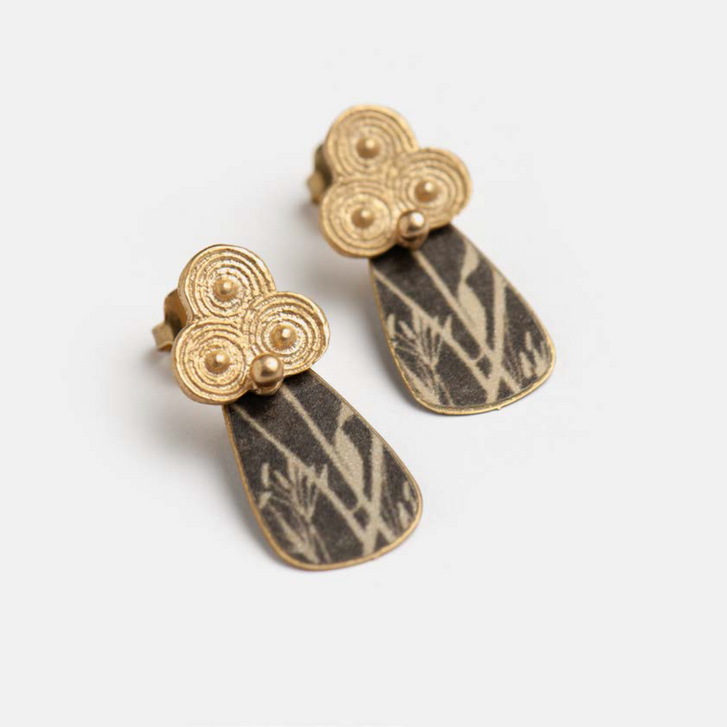 Pair of teardrop earrings; dark gray patterned metal with gold clover-shaped tops.