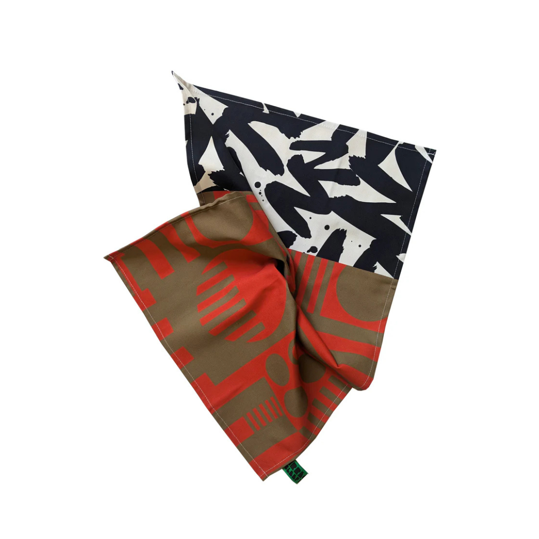 Abstract patterned tea towel in red, brown, black, and white.  Folded to show both sides of the design.