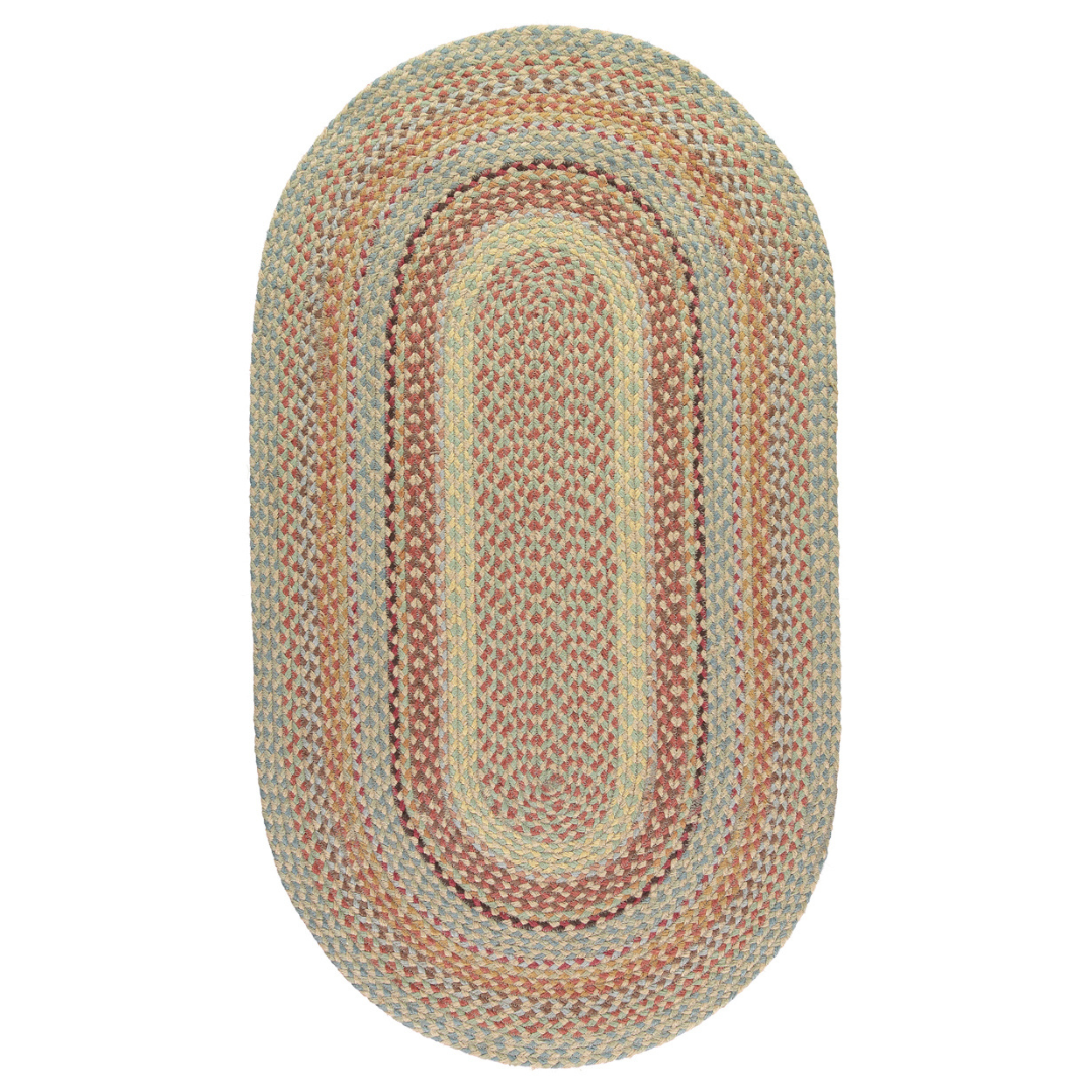 Oval braided rug in muted greens, tans, and reds.