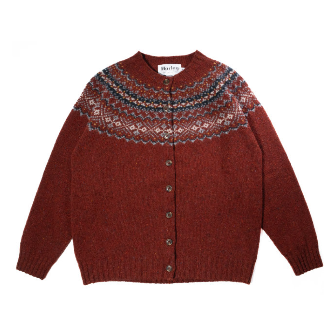 A red cardigan with a Fairisle knit pattern in multicolor, displayed on a flat surface.