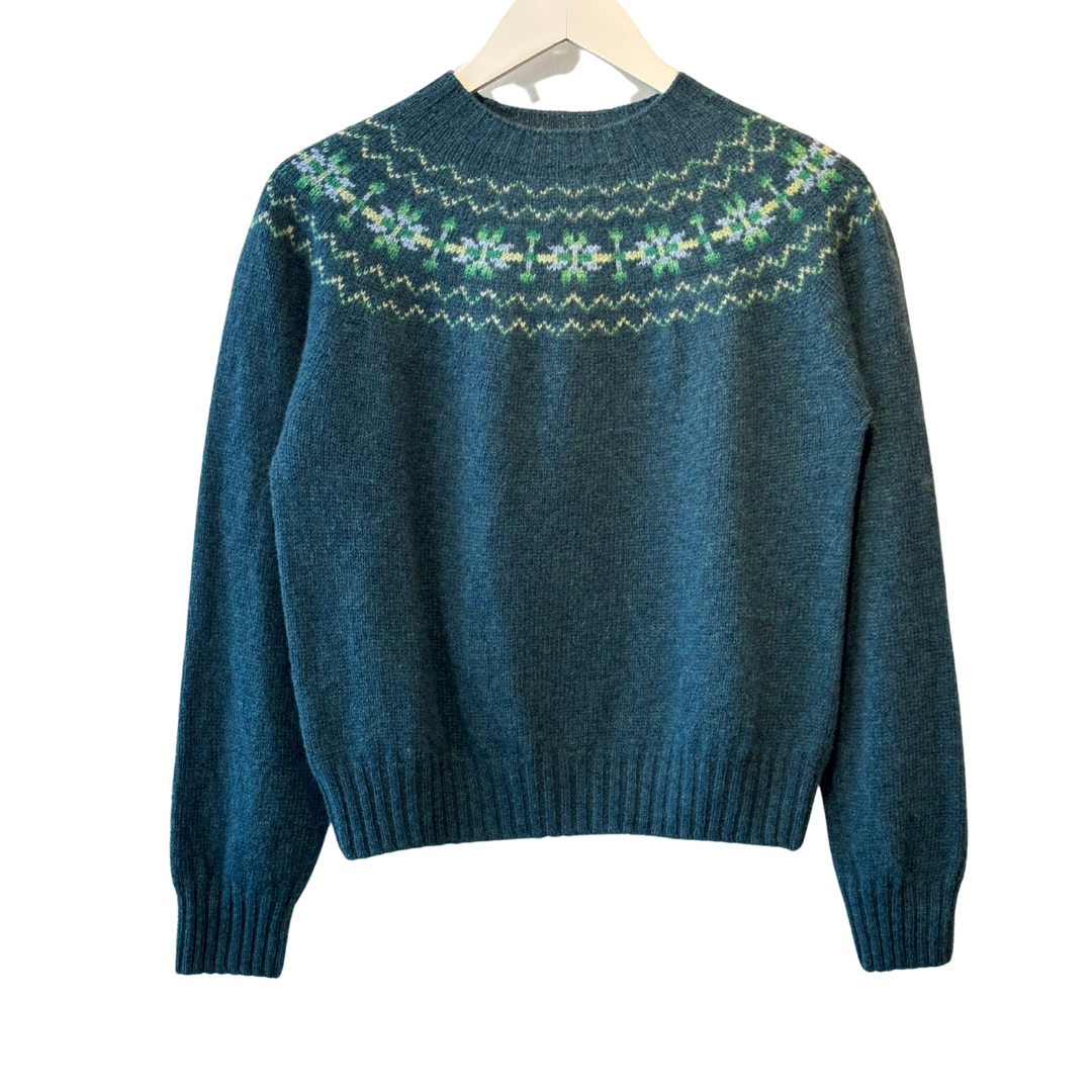 Dark teal crewneck sweater with a Fair Isle-style yoke featuring green, yellow, and light purple details.