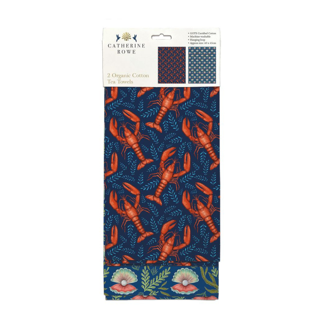 Set of two organic cotton tea towels. One features a lobster pattern on a navy background, the other a floral design.