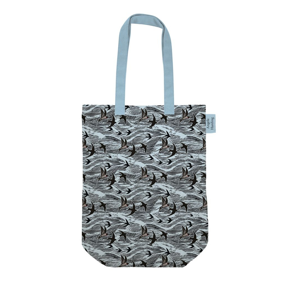 Light blue tote bag featuring a repeating pattern of dark birds in flight over a wavy design.