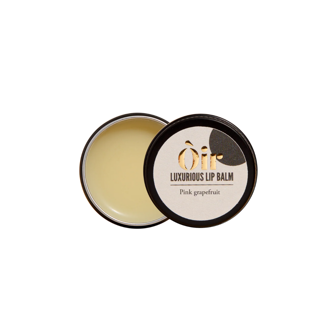 Luxurious lip balm with pink grapefruit scent in a black container on a white background